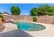Sparkling pool featuring a rock waterfall, lounge chairs, and lush landscaping, creating a serene outdoor oasis at 7236 W Aurora Dr, Glendale, AZ 85308