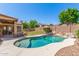 Inviting backyard pool area with comfortable lounge furniture, rock accents, and lush landscaping at 7236 W Aurora Dr, Glendale, AZ 85308