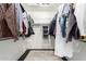 A walk-in closet with hanging shirts and clothes is accessorized with a neutral patterned rug at 7236 W Aurora Dr, Glendale, AZ 85308