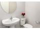 Powder bathroom features a pedestal sink, toilet, round mirror, and neutral decor at 7251 E Portobello Ave, Mesa, AZ 85212