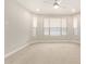 Spacious bedroom with neutral carpet, ceiling fan, and bright natural light from large windows at 7251 E Portobello Ave, Mesa, AZ 85212