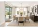 Elegant dining room with a modern chandelier, a large table, and sliding glass doors to the backyard at 7251 E Portobello Ave, Mesa, AZ 85212
