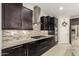 Gourmet kitchen with gas cooktop, granite counters, stainless steel appliances, and ample cabinet space at 7251 E Portobello Ave, Mesa, AZ 85212