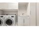 Laundry room with a washer and dryer and storage cabinets above a sink at 7251 E Portobello Ave, Mesa, AZ 85212