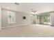 Spacious living room with neutral carpet, ceiling fan, and sliding glass doors to the backyard at 7251 E Portobello Ave, Mesa, AZ 85212