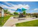 A shaded community playground also features benches, signage and mature trees at 7251 E Portobello Ave, Mesa, AZ 85212