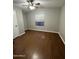 Cozy bedroom featuring durable wood flooring, a modern ceiling fan and light fixture, and a large bright window at 8103 E Southern Ave # 279, Mesa, AZ 85209