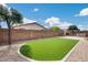 Low maintenance backyard featuring pavers, turf, fireplace, and an outdoor kitchen with built-in BBQ at 9165 W Mine Trl, Peoria, AZ 85383