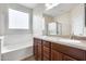 The bathroom features a double sink vanity, large mirror and separate shower and tub at 9165 W Mine Trl, Peoria, AZ 85383