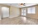 Spacious bedroom with wood-look floors, a ceiling fan, and French doors that let in natural light at 9165 W Mine Trl, Peoria, AZ 85383