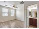 Light filled bedroom features wood floors, ceiling fan, ensuite bath, and two bright windows at 9165 W Mine Trl, Peoria, AZ 85383