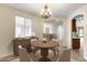 Elegant dining room with wood table, chandelier, cabinet, and lots of natural light from the window at 9165 W Mine Trl, Peoria, AZ 85383