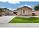 Attractive single-Gathering home with a well-manicured lawn, stone accents, and inviting curb appeal at 9165 W Mine Trl, Peoria, AZ 85383