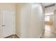 Hallway with light hardwood floors and a white paneled door at 9165 W Mine Trl, Peoria, AZ 85383