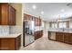 Spacious kitchen featuring stainless steel appliances, rich wood cabinetry, and bright countertops at 9165 W Mine Trl, Peoria, AZ 85383