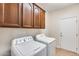 Functional laundry room with washer, dryer, and built-in cabinets for organized and efficient chore management at 9165 W Mine Trl, Peoria, AZ 85383