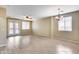 Bright and airy living room with tile and wood flooring, ceiling fan, and elegant light fixture at 9165 W Mine Trl, Peoria, AZ 85383