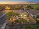 Sunset aerial view of a property showcasing a well-maintained backyard with a putting green and patio at 10335 E Morning Star Dr, Scottsdale, AZ 85255