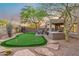Beautiful backyard featuring a putting green, seating area, mature trees and a hot tub at 10335 E Morning Star Dr, Scottsdale, AZ 85255