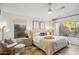 Bright bedroom featuring a ceiling fan, a comfortable bed, and natural light from windows overlooking the yard at 10335 E Morning Star Dr, Scottsdale, AZ 85255