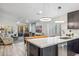 Modern kitchen island overlooking the adjacent living room with bright light fixtures and marble countertops at 10335 E Morning Star Dr, Scottsdale, AZ 85255