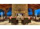 Outdoor seating area with a stone fireplace and city views at night at 10335 E Morning Star Dr, Scottsdale, AZ 85255