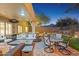 Covered patio featuring comfortable seating, a fire pit, and views of the meticulously landscaped backyard at 10335 E Morning Star Dr, Scottsdale, AZ 85255