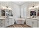 Bathroom with dual sinks, soaking tub, decorative wallpaper and flooring at 11013 E Decatur St, Mesa, AZ 85207