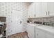 Clean laundry room with washer, dryer, cabinets, countertop, and decorative wallpaper at 11013 E Decatur St, Mesa, AZ 85207