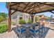 Charming outdoor dining area with a pergola, built-in grill, and backyard views at 11013 E Decatur St, Mesa, AZ 85207