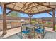 Outdoor kitchen and dining area under a shaded pergola with a built-in grill and seating at 11013 E Decatur St, Mesa, AZ 85207