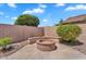 Lush backyard featuring a charming fire pit area surrounded by vibrant greenery and a privacy wall at 11040 E Nichols Ave, Mesa, AZ 85209