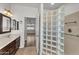 Bathroom with glass block partition, tile shower, and double sink vanity at 11040 E Nichols Ave, Mesa, AZ 85209