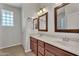 Bright bathroom with double sink vanity, wood cabinets and decorative lighting at 11040 E Nichols Ave, Mesa, AZ 85209