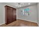 Bright bedroom features a murphy bed, wood floors, ceiling fan, and natural light at 11040 E Nichols Ave, Mesa, AZ 85209