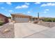 A home with a two-car garage and a desert rock garden in the front at 11040 E Nichols Ave, Mesa, AZ 85209
