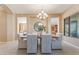 Spacious dining room boasts a modern chandelier, large windows, and seamless transition to the kitchen at 12820 W La Vina Dr, Sun City West, AZ 85375