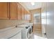 Well-equipped laundry room boasts ample cabinet storage, countertop space, and modern washer and dryer units at 12820 W La Vina Dr, Sun City West, AZ 85375