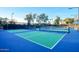 Community tennis courts with vibrant blue and green surface and ample lighting at 12820 W La Vina Dr, Sun City West, AZ 85375
