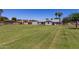 View of home with a large manicured lawn, mature trees, and an outbuilding at 1551 E Longhorn Dr, Chandler, AZ 85286