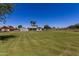View of home with a large manicured lawn, mature trees, and an outbuilding at 1551 E Longhorn Dr, Chandler, AZ 85286