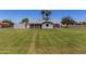 View of home with a large manicured lawn, mature trees, and an outbuilding at 1551 E Longhorn Dr, Chandler, AZ 85286