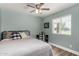 Bright bedroom with a ceiling fan, wood-look flooring, a large window, and a plaid chair at a small desk at 1551 E Longhorn Dr, Chandler, AZ 85286