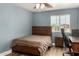 Simple bedroom with a wood framed bed, medium blue walls, and a desk, with a neighborhood view at 1551 E Longhorn Dr, Chandler, AZ 85286