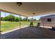 Covered patio with white railing overlooking a large grassy yard with mature trees at 1551 E Longhorn Dr, Chandler, AZ 85286