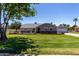 Charming single-story home featuring a well-maintained lawn, mature trees, and a detached garage with a basketball hoop at 1551 E Longhorn Dr, Chandler, AZ 85286