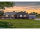 Charming single-story home with a brick foundation, well-manicured lawn, and a detached garage at sunset at 1551 E Longhorn Dr, Chandler, AZ 85286