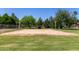 Sand volleyball court in a well-manicured yard with mature trees in the background at 1551 E Longhorn Dr, Chandler, AZ 85286