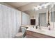 Neutral bathroom with modern lighting fixture, large mirror, and shower with marble-patterned curtain at 17424 N 1St Ave, Phoenix, AZ 85023