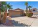 Charming single-story home featuring a two-car garage, desert landscaping, and mature palm trees on a sunny day at 17424 N 1St Ave, Phoenix, AZ 85023